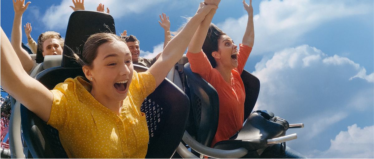 Friends throwing their hands up on a roller coaster